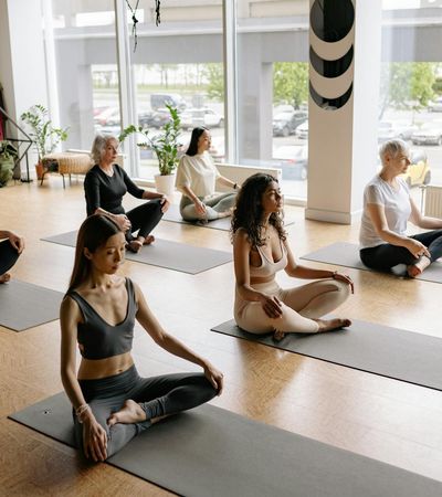 Woman in a calm yoga pose, sitting on a mat.