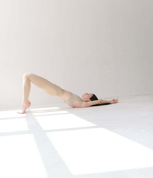 Woman in a peaceful yoga pose, aquamarine light accents.