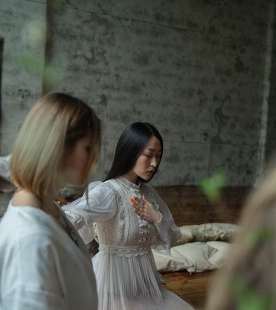 Woman meditating in soft light, symbolizing energy and calm.
